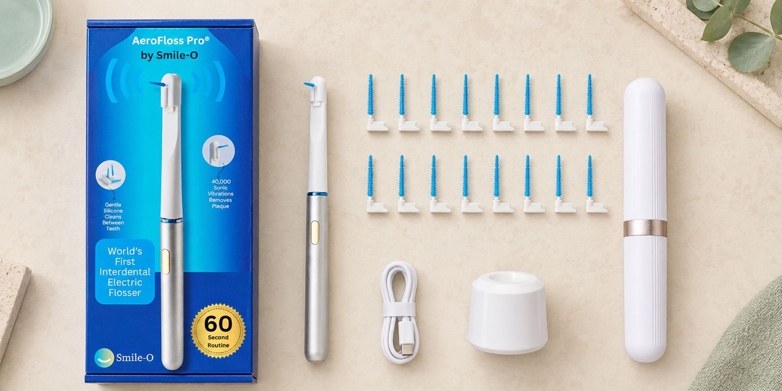 AeroFloss Pro box contents laid out: device, 15 tips, charging base, travel case, cable