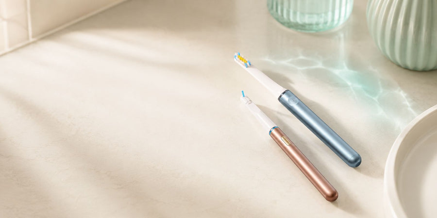 AeroBrush Pro and AeroFloss Pro lying side by side on a cream counter